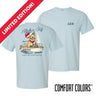 Light blue Comfort Colors t-shirt shown front and back; front features small Greek letters on the left chest, back displays a golden retriever sailing a boat with script text above and “Chasing Open Water” below.