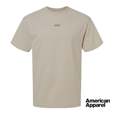 Beige short sleeve crewneck t-shirt with small embroidered text at the center chest on a clean background.