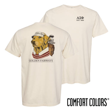 Golf-themed fraternity t-shirt on ivory Comfort Colors tee featuring a golden retriever wearing a golf hat and striped polo with golf clubs on the back. Perfect for fraternity golf events, rush, and casual campus wear.